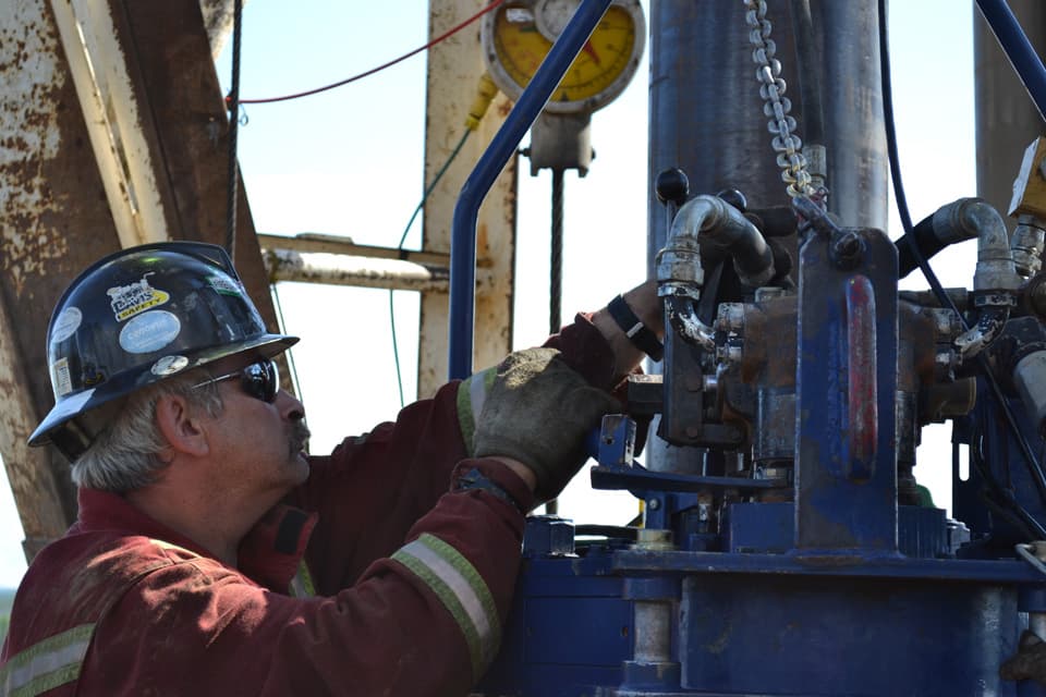 Operator guiding tongs onto the string