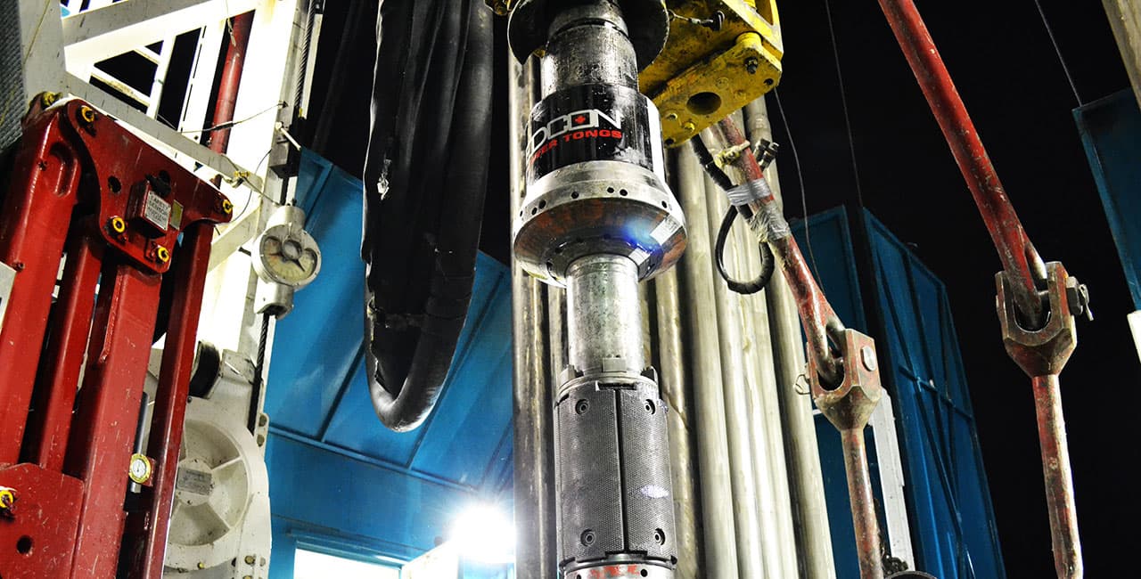 Edcon power tong suspended in the derrick during a night casing run